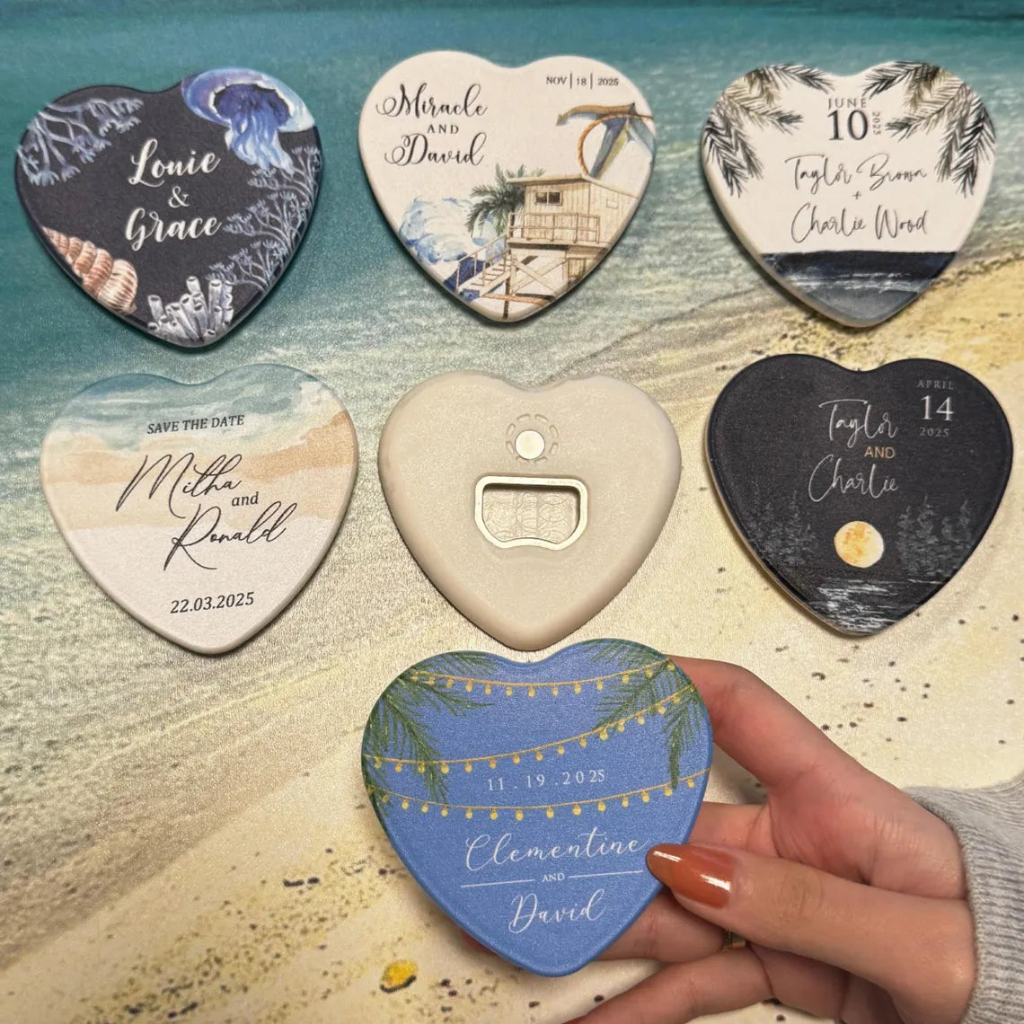 Personalized heart-shaped magnets and bottle openers as wedding favors on a beach background.